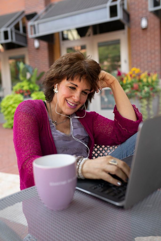 Tama Kieves coaching through her laptop outside by a patio table